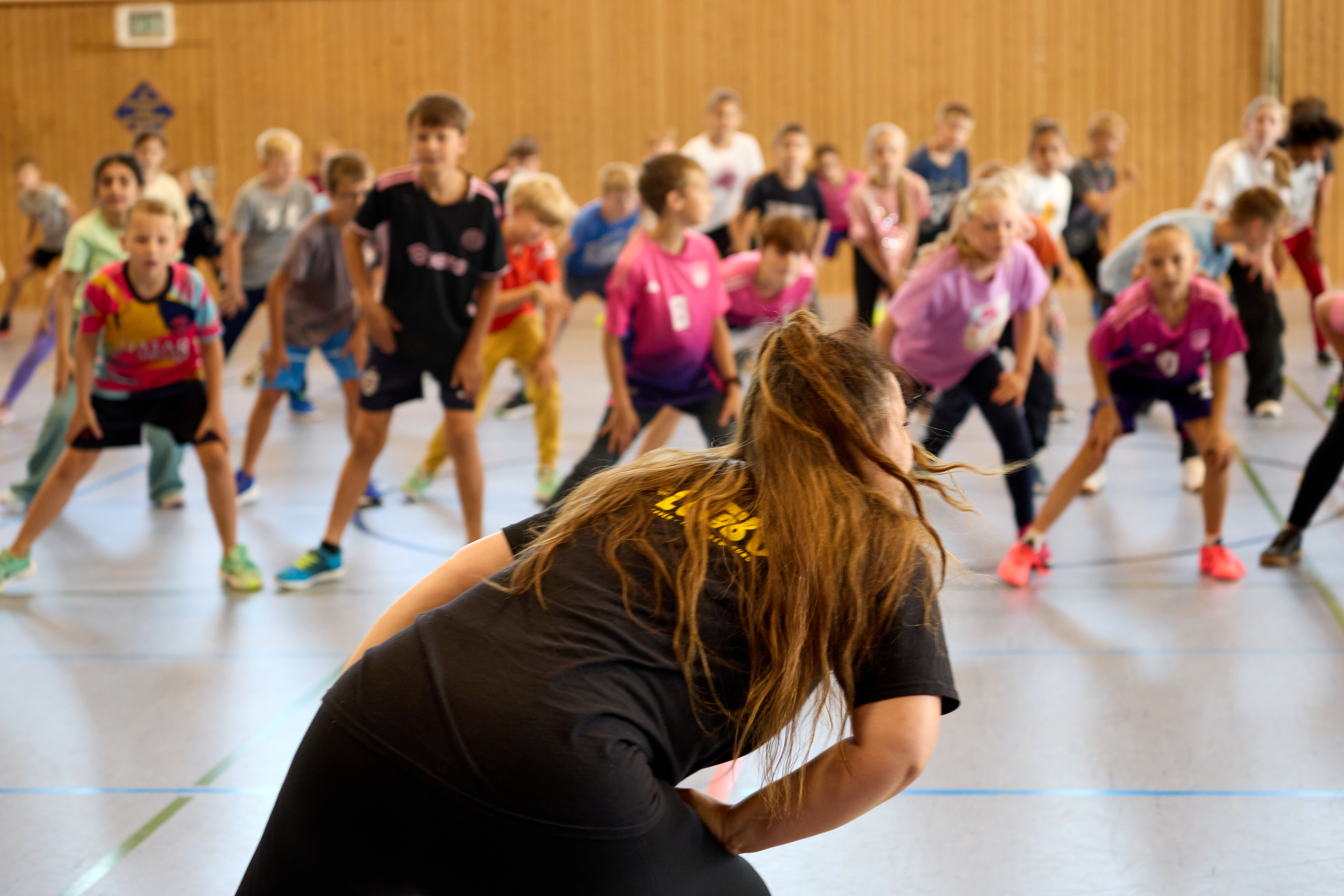 LeTaBe-Referentin leitet eine große Gruppe in der Sporthalle an