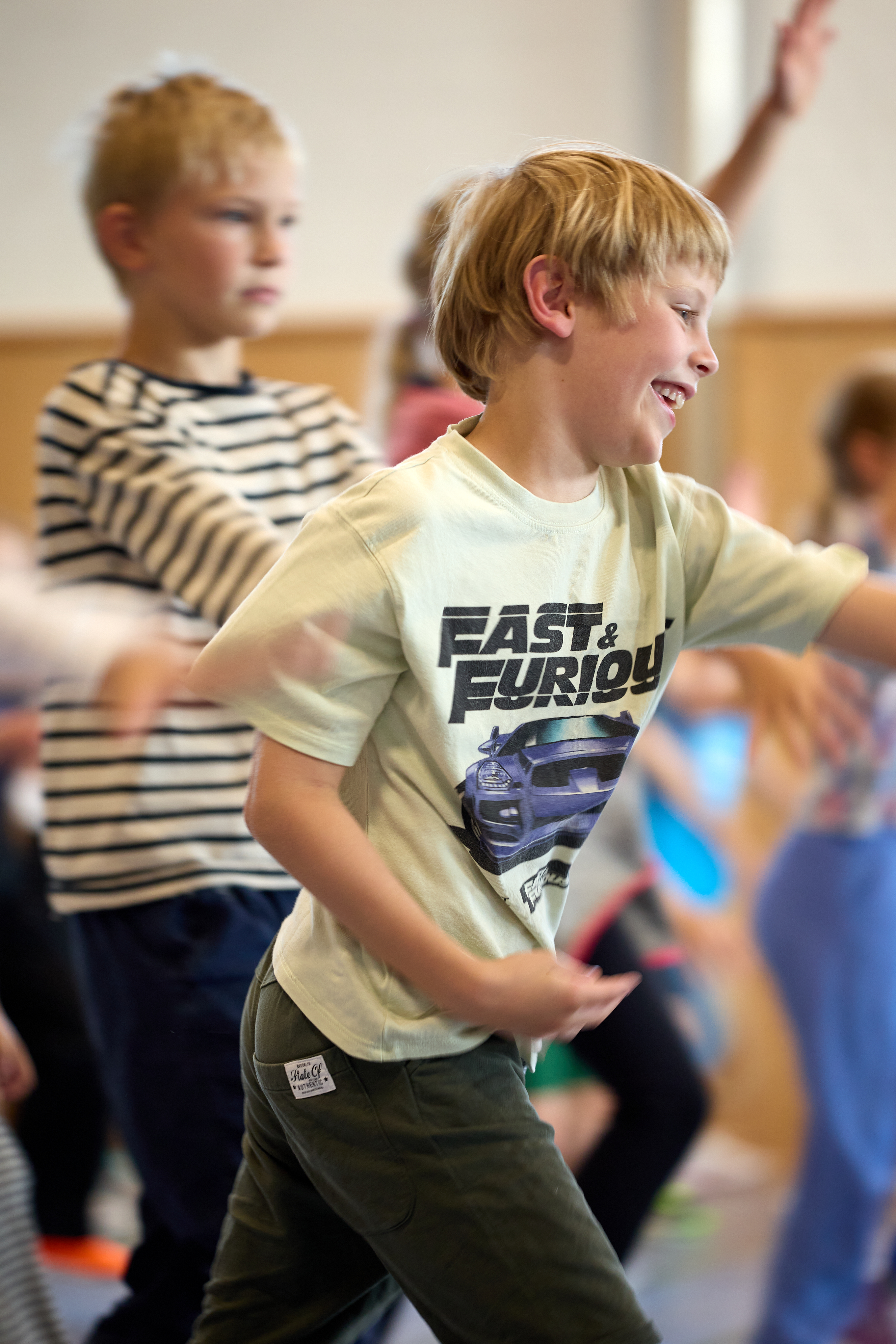 Lachender Junge tanzt bei den LeTaBe-Tanzprojekttagen