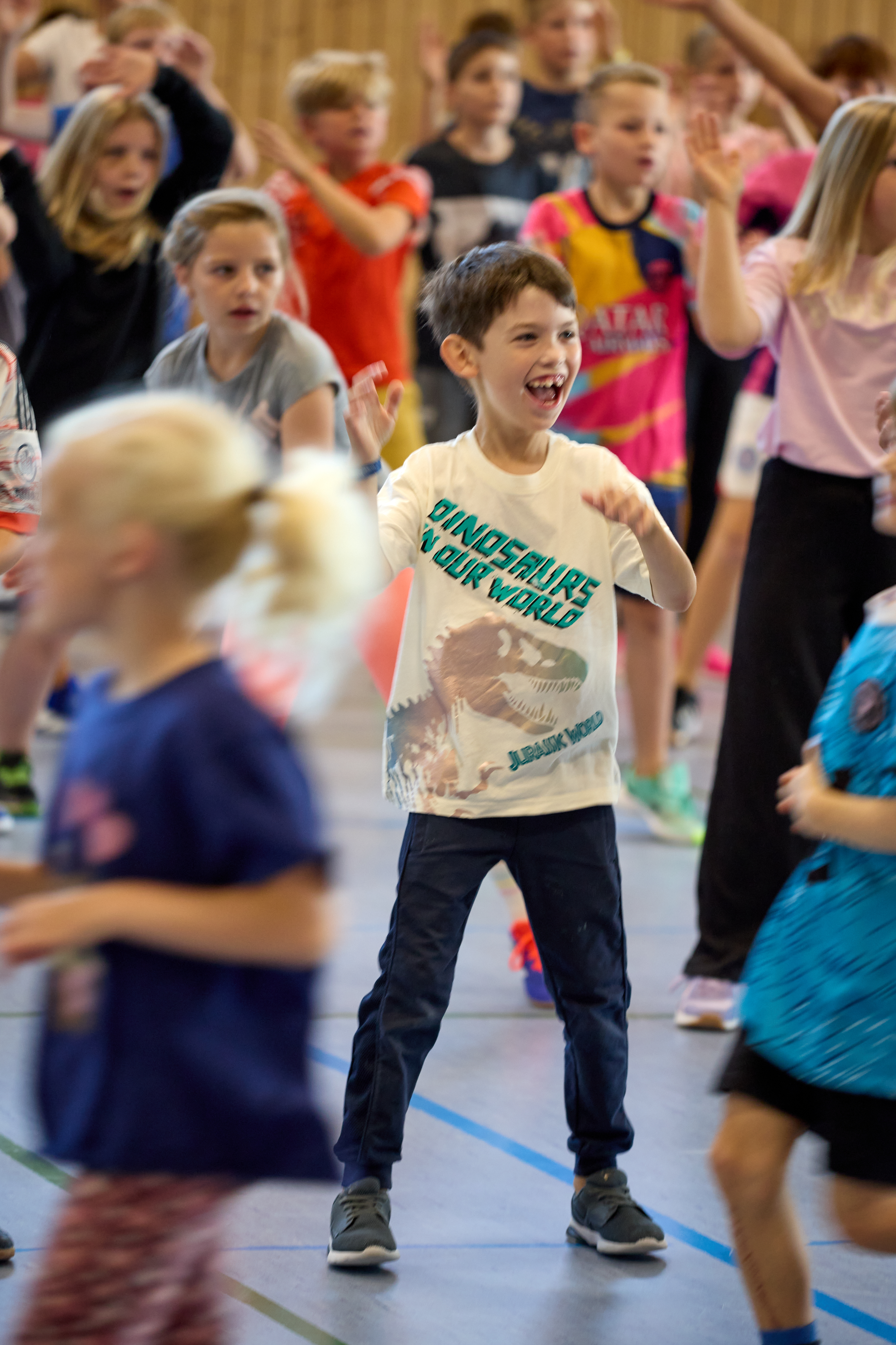 Lachender Junge tanzt beim LeTaBe-Projekt in der Sporthalle