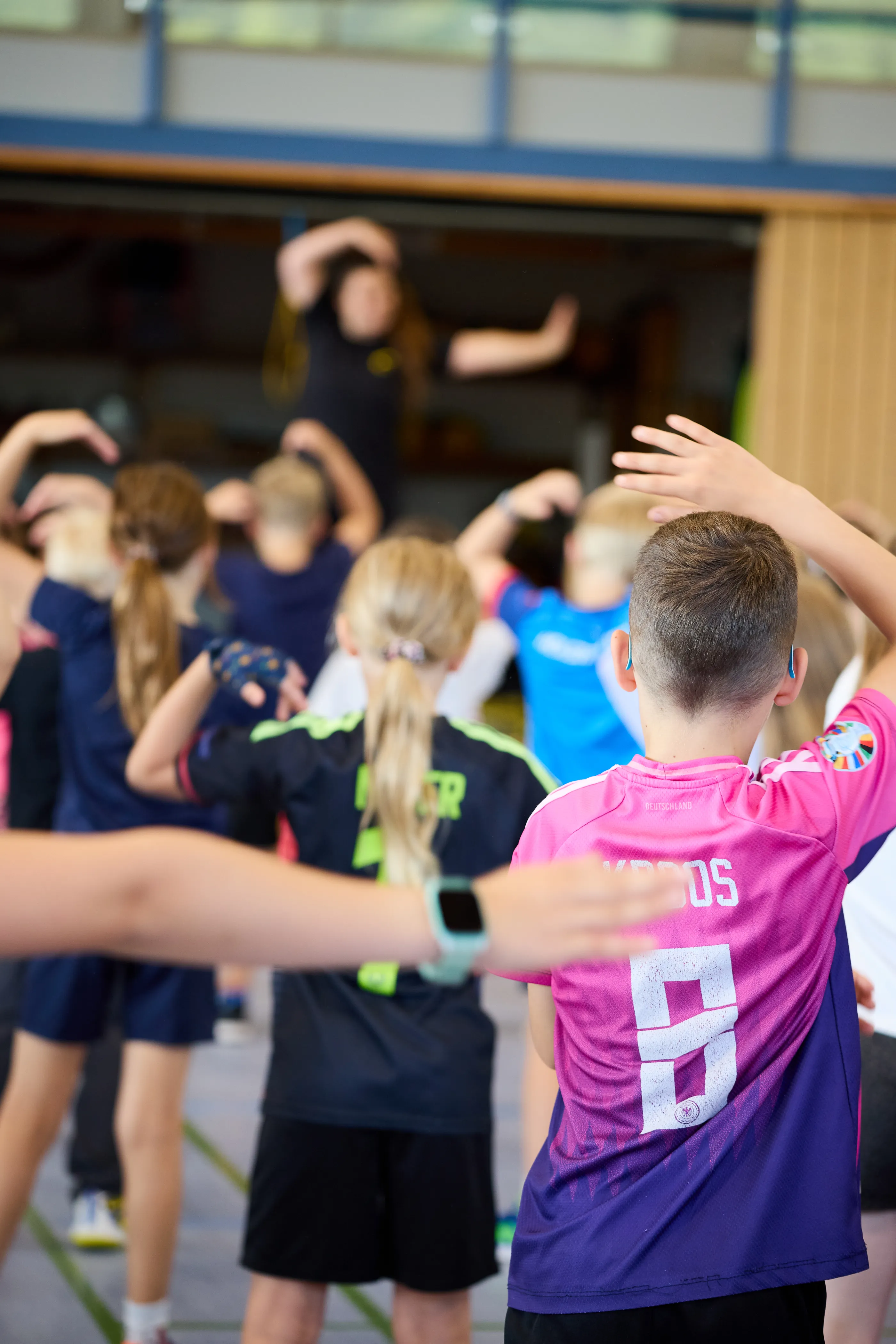 Kinder beim gemeinsamen Aufwärmen in der Turnhalle