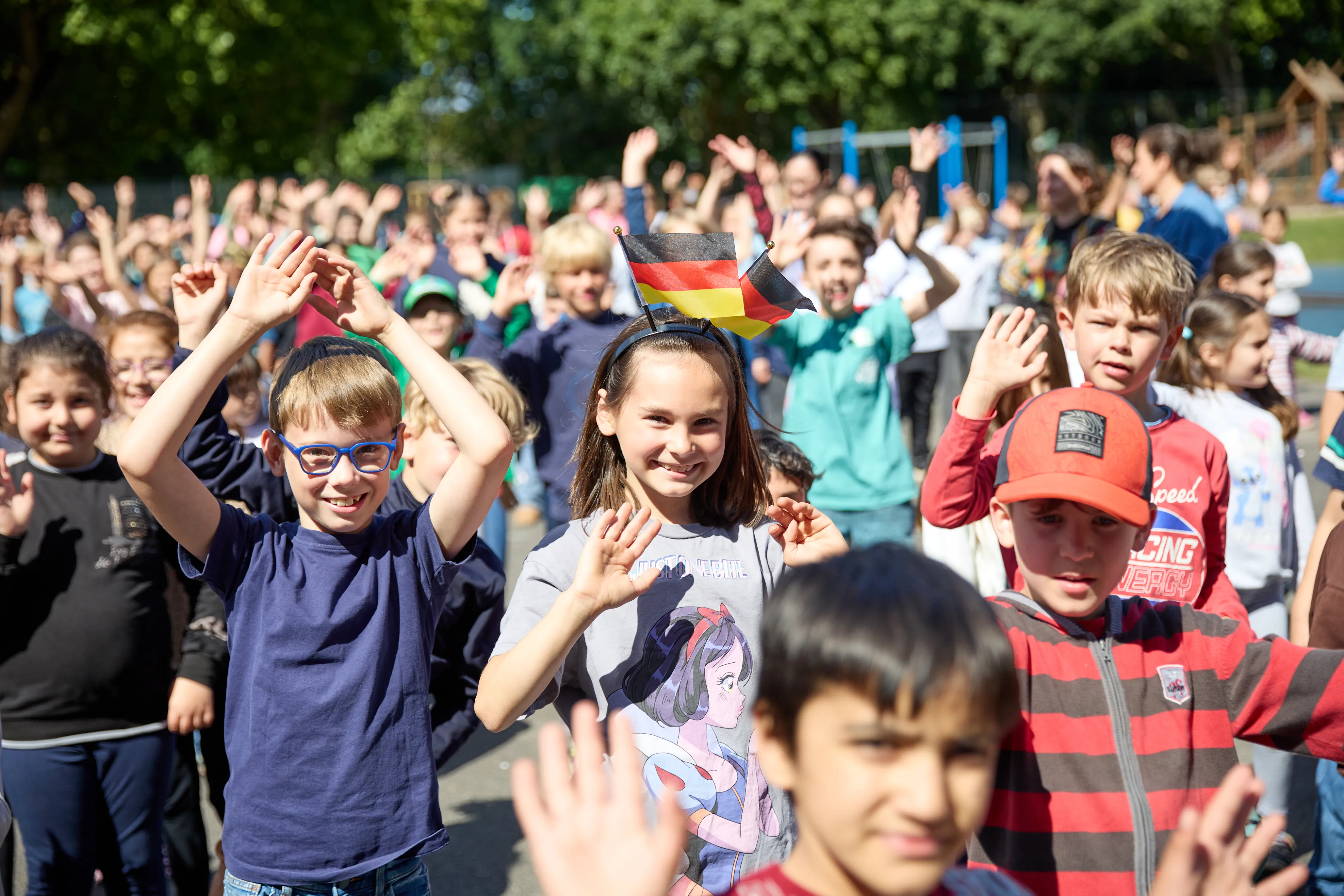 Große Gruppe Kinder tanzt gemeinsam auf dem Schulhof